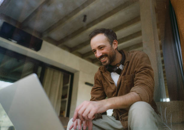 istock Man using a laptop in a cabin house 2198220819