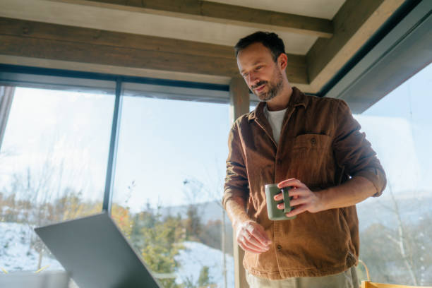 istock Man using a laptop in a cabin house 2198220883