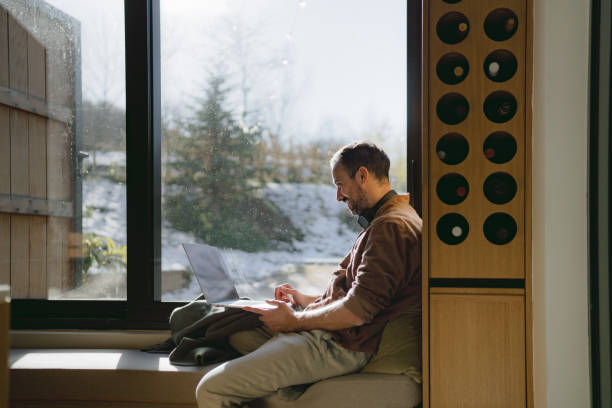 istock Man using a laptop in a cabin house 2198220888
