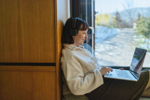 istock Woman using a laptop in a cabin house 2198220904