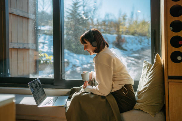 istock Woman using a laptop in a cabin house 2198220908