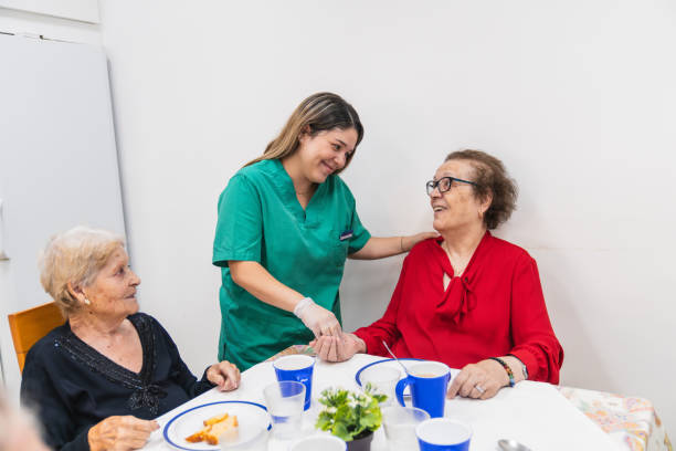 istock Caring nurse interacting with elderly residents in nursing home 2198220911