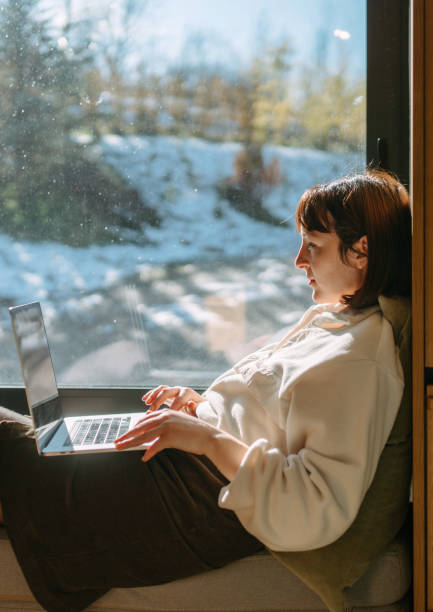 istock Woman using a laptop in a cabin house 2198220924