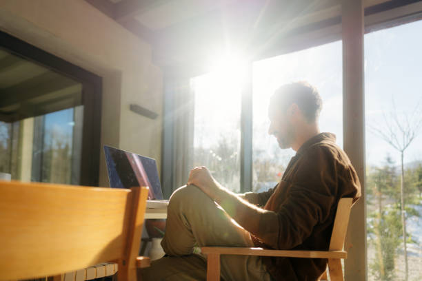 istock Man using a laptop in a cabin house 2198220931