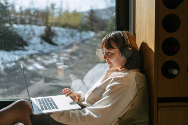 istock Woman using a laptop in a cabin house 2198220935