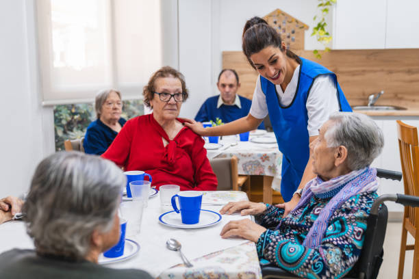 istock Caring nurse interacting with senior adults in nursing home 2198221480