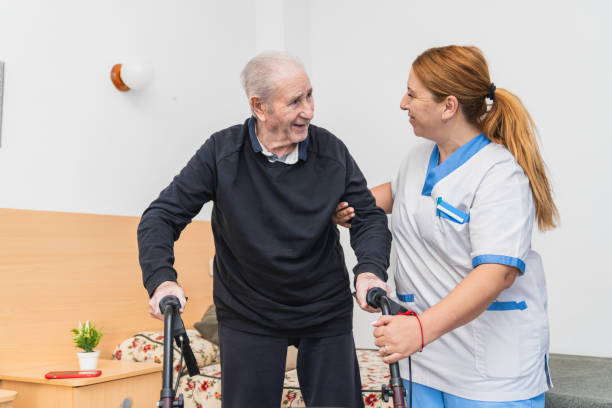 istock Caring nurse assisting elderly man in nursing home 2198221597