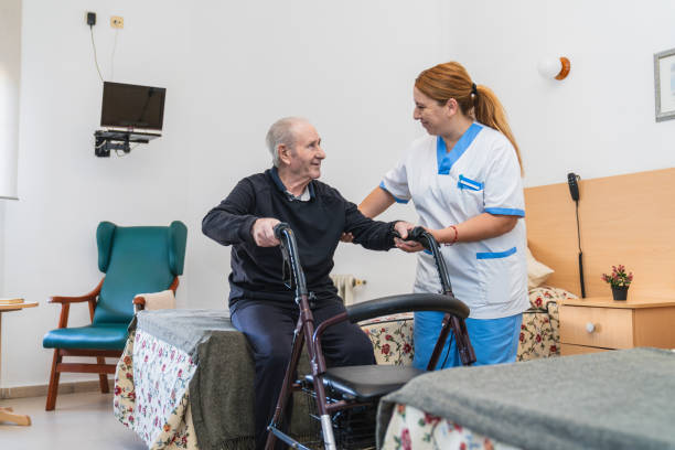 istock Caring nurse assisting senior man with walker 2198221600