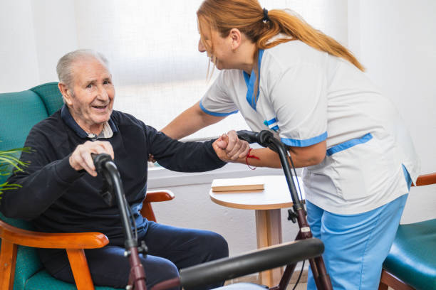 istock Caring nurse assisting senior man with walker 2198221910