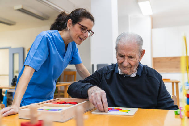 istock Caring nurse assisting senior man in nursing home 2198222087