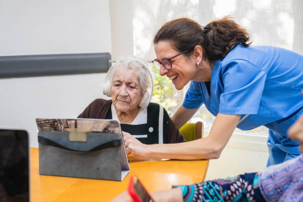 istock Caring nurse assisting elderly woman with tablet 2198222187