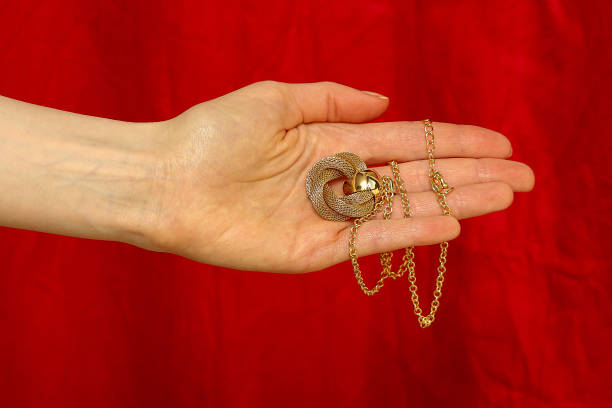 Close-up of a Hamsa hand silver pendant featuring a vibrant purple gemstone, symbolizing protection and luck