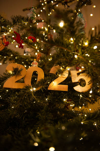 istock Vertical Golden 2025 Ornament on Christmas Tree with Lights 2198243858
