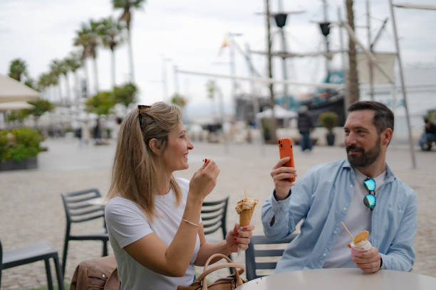 istock man taking picture os woman while sharing ice cream 2198243933