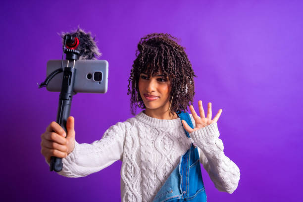 Young woman vlogger recording a video blog using her smartphone