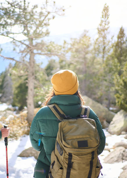 istock Hikers walking in snowy mountain forest enjoying scenic view 2198255368