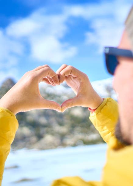 istock Man making heart shape with hands in winter landscape 2198255470