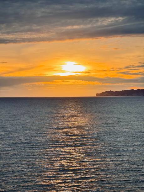 istock Golden Sunset Over the Ocean with Reflections on Water 2198255795