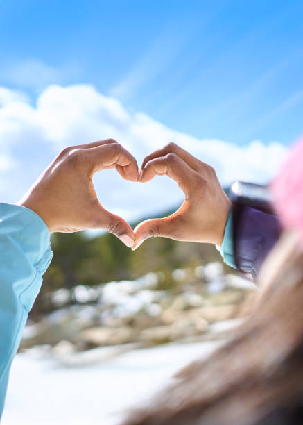 istock Woman making heart shape with hands in winter landscape 2198257821