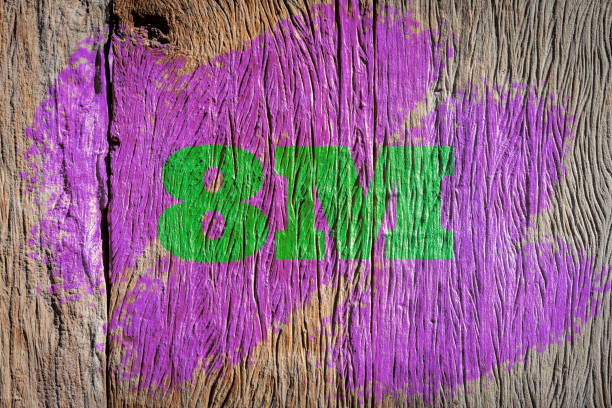 Rough wood with green 8M text and weathered purple paint.