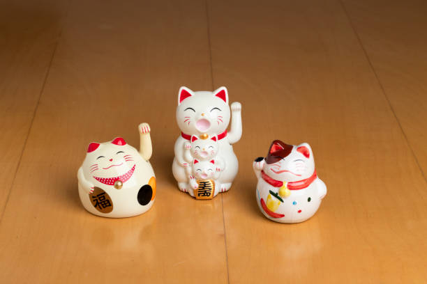 istock Three white maneki neko cat figures with their paws up for good luck 2198264949