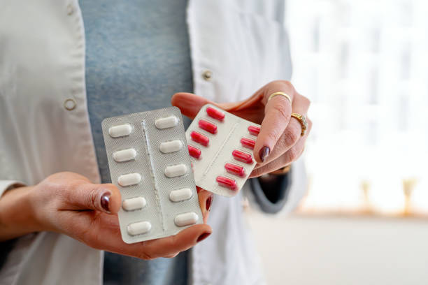 istock Pharmacist presenting medication tablets and capsules in hands close-up 2198268674