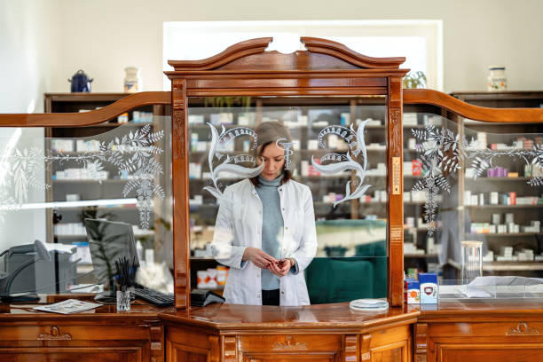 A professional pharmacist performing tasks behind a finely carved wooden counter in a cozy pharmacy setting. Includes shelves filled with medical supplies, showcasing an organized and traditional healthcare environment. A blend of professionalism, patient care, and heritage is clearly depicted in the ambient design and attire.
