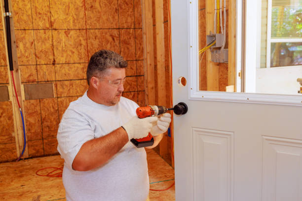 istock Professional locksmith installing a lock on entrance door of house using screwdriver 2198274785