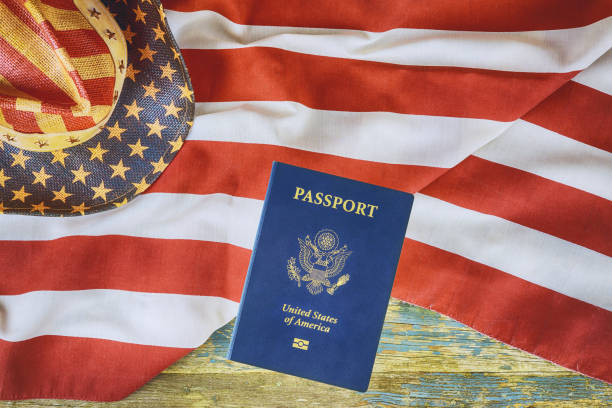 istock Over American flag is American passport, which represents citizenship a naturalization 2198274918
