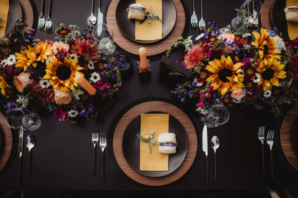 Flowers and centerpieces on wedding reception table set for dinner