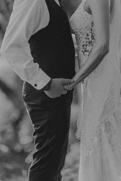 istock Close up of bride and groom holding hands in black and white 2198292715