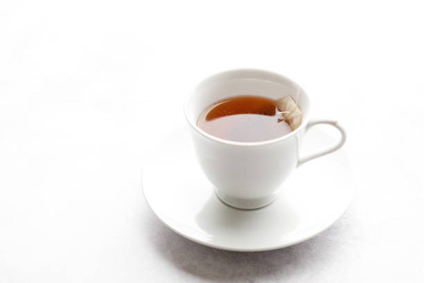 istock Cup of hot tea with tea bag on white table background. 2198298556