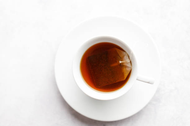 Cup of hot tea with tea bag on white table background. selective focus.