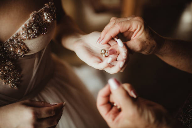 istock Mother helping daughter bride on her wedding day getting dressed 2198300225