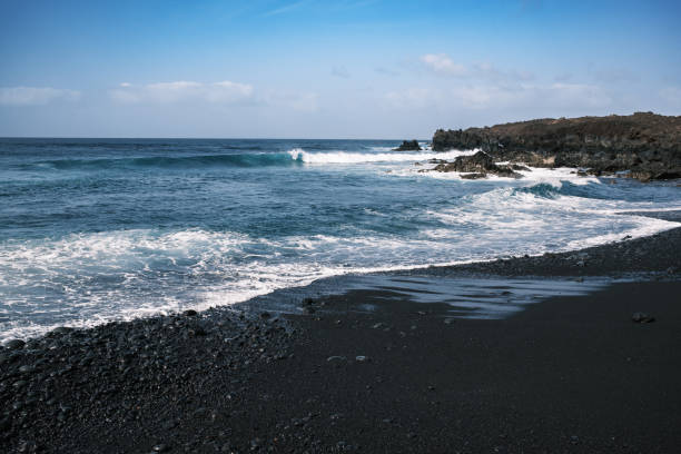 istock Volcanic Pebble Beach in Lanzarote: Rugged Coastline and Ocean Waves 2198312351