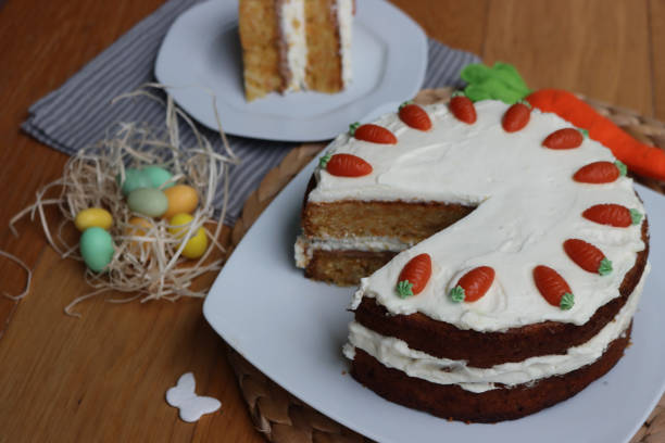 istock Sliced  carrot cake with mascarpone cream cheese and carrot decorations with Easter eggs and decorations 2198314306