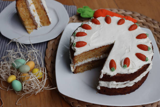 istock Sliced  carrot cake with mascarpone cream cheese and carrot decorations with Easter eggs and decorations 2198314343