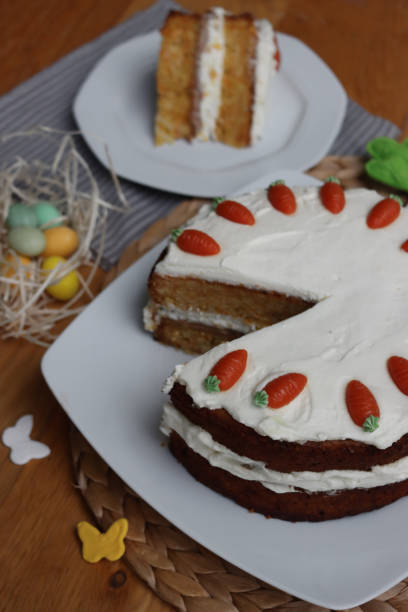 istock Sliced  carrot cake with mascarpone cream cheese and carrot decorations with Easter eggs and decorations 2198314390