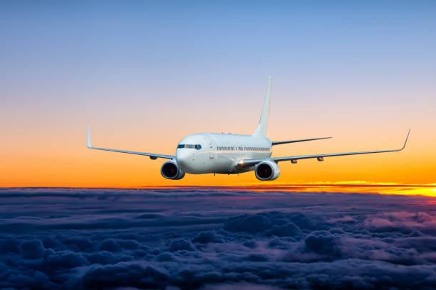 istock White passenger aircraft is flying in the sunset sky 2198315893