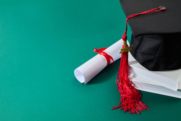 istock Graduation Celebration. A graduation cap with a red tassel and a diploma 2198319793