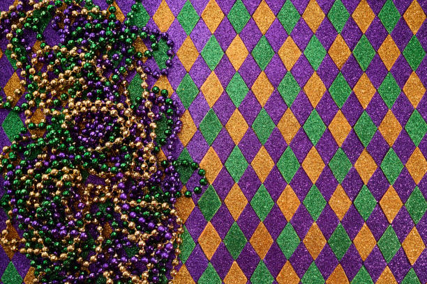This image shows a full frame macro texture background of multi colored defocused Mardi Gras bead necklaces.