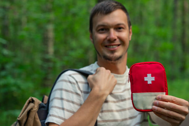 istock Smiling Man Holding First Aid Kit While Hiking in Forest, Prepared for Outdoor Adventure 2198319862