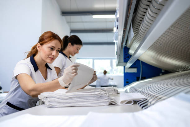 istock Dry cleaning service. Folding clean laundry and preparing for packing. 2198320580