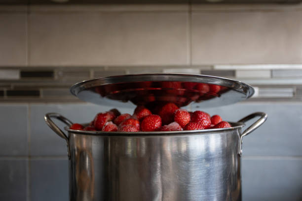 A vibrant pot filled with fresh, ripe strawberries, ideal for cooking or preserving delightful treats