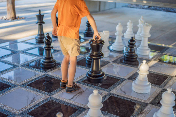 istock Father and son playing chess spending time together outdoor. Kid play chess 2198321955