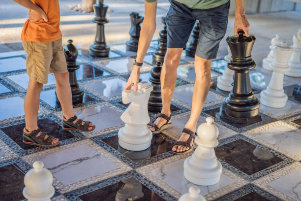 istock Father and son playing chess spending time together outdoor. Kid play chess 2198321963