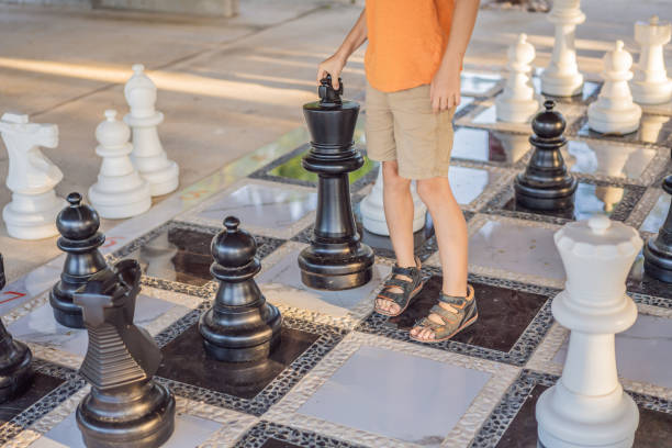 istock Father and son playing chess spending time together outdoor. Kid play chess 2198321967