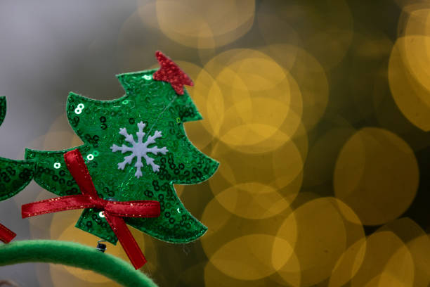 This colorful ornament shows a beautifully designed Christmas tree with sequins against a lovely bokeh background