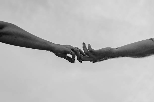 istock Black and white image of two hands reaching out, symbolizing connection and support 2198323692