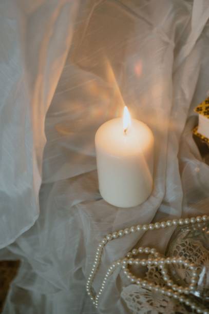 istock Glowing candle paired with an elegant pearl necklace 2198323707
